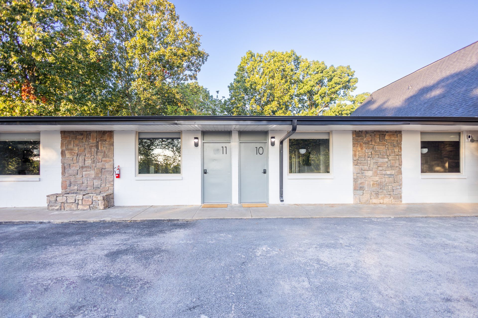 Exterior photo of the rooms which have gray doors and a modern light.