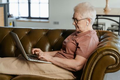 Older woman using a laptop at home, supported to live independently