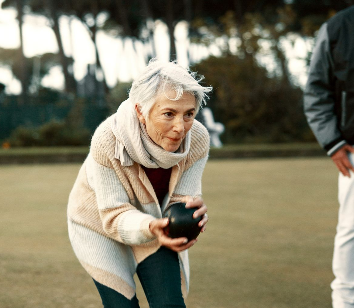 Elderly woman being supported by a carer during a community outing