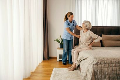 Support worker assisting an elderly woman in her living room