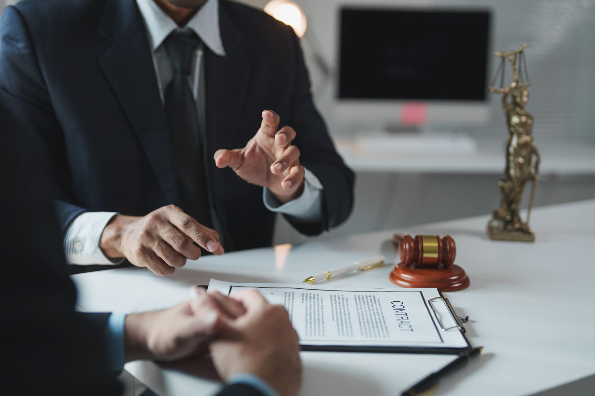 Business meeting with lawyers reviewing documents beside a gavel and statue on a desk