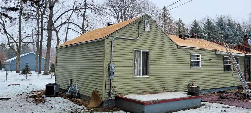 House with new roofing on a snowy day.
