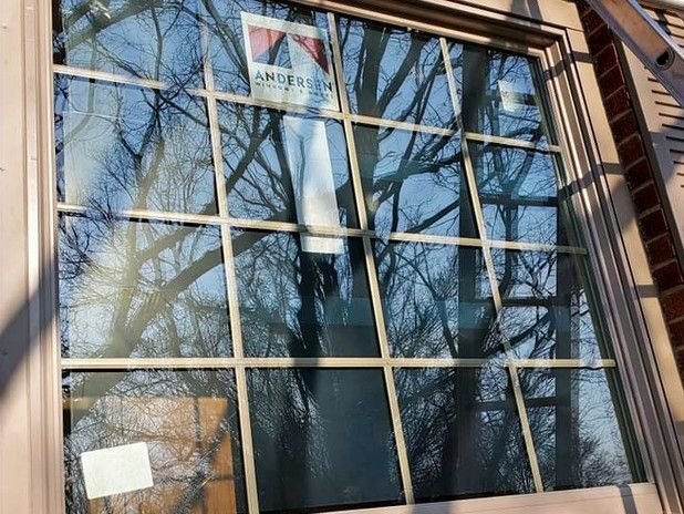 New window with grid pattern reflecting trees and sky. Anderson label visible.