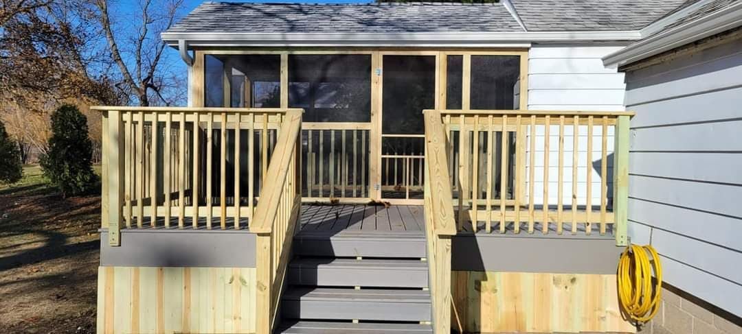 Wooden deck with steps leading to a screened porch. Grey steps and wooden railings. Blue sky background.