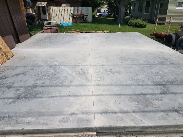 Concrete slab, freshly poured, for a structure's foundation. Outdoor setting, daylight.