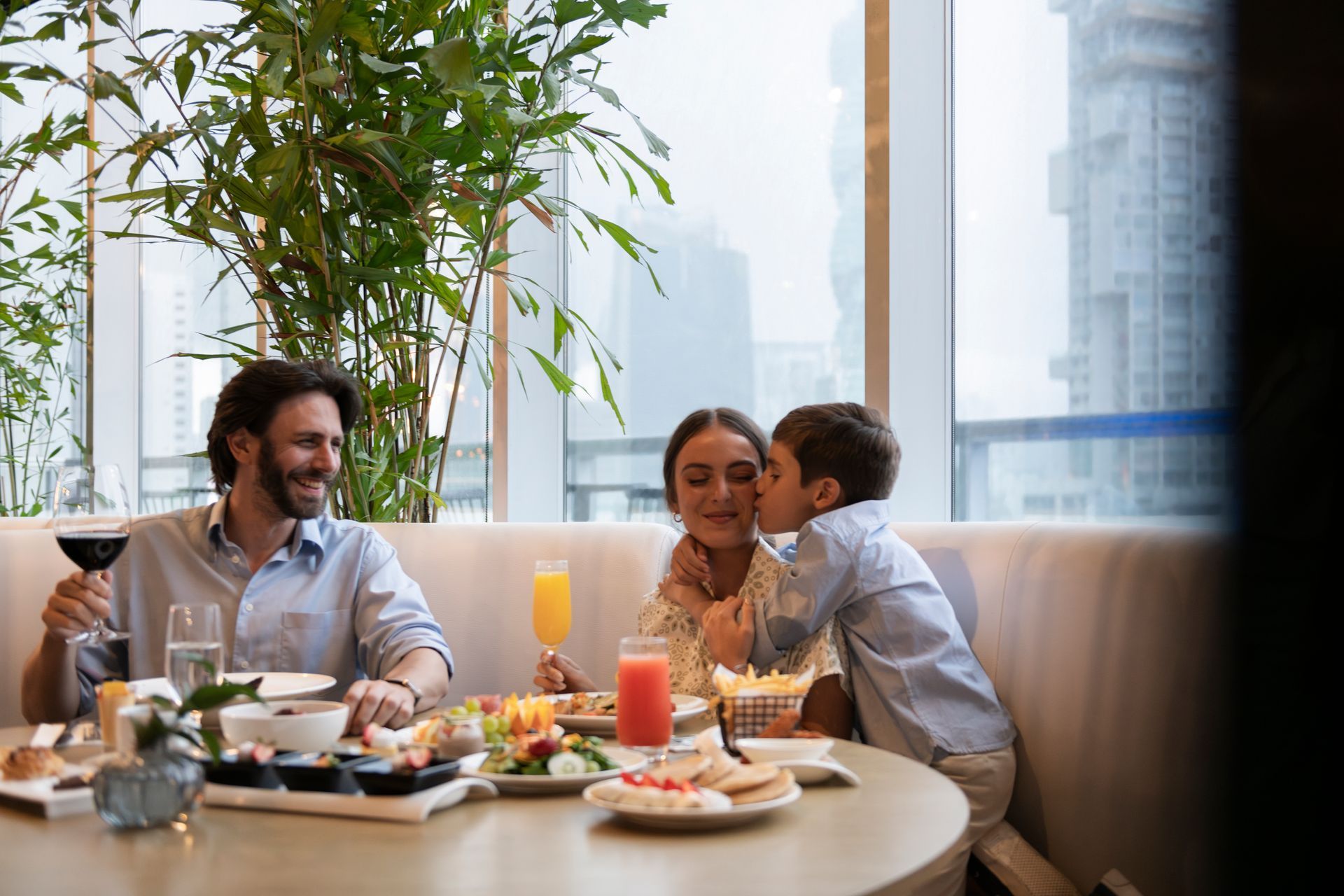 Una mesa cubierta con platos de comida y bebidas con vista a la ciudad.