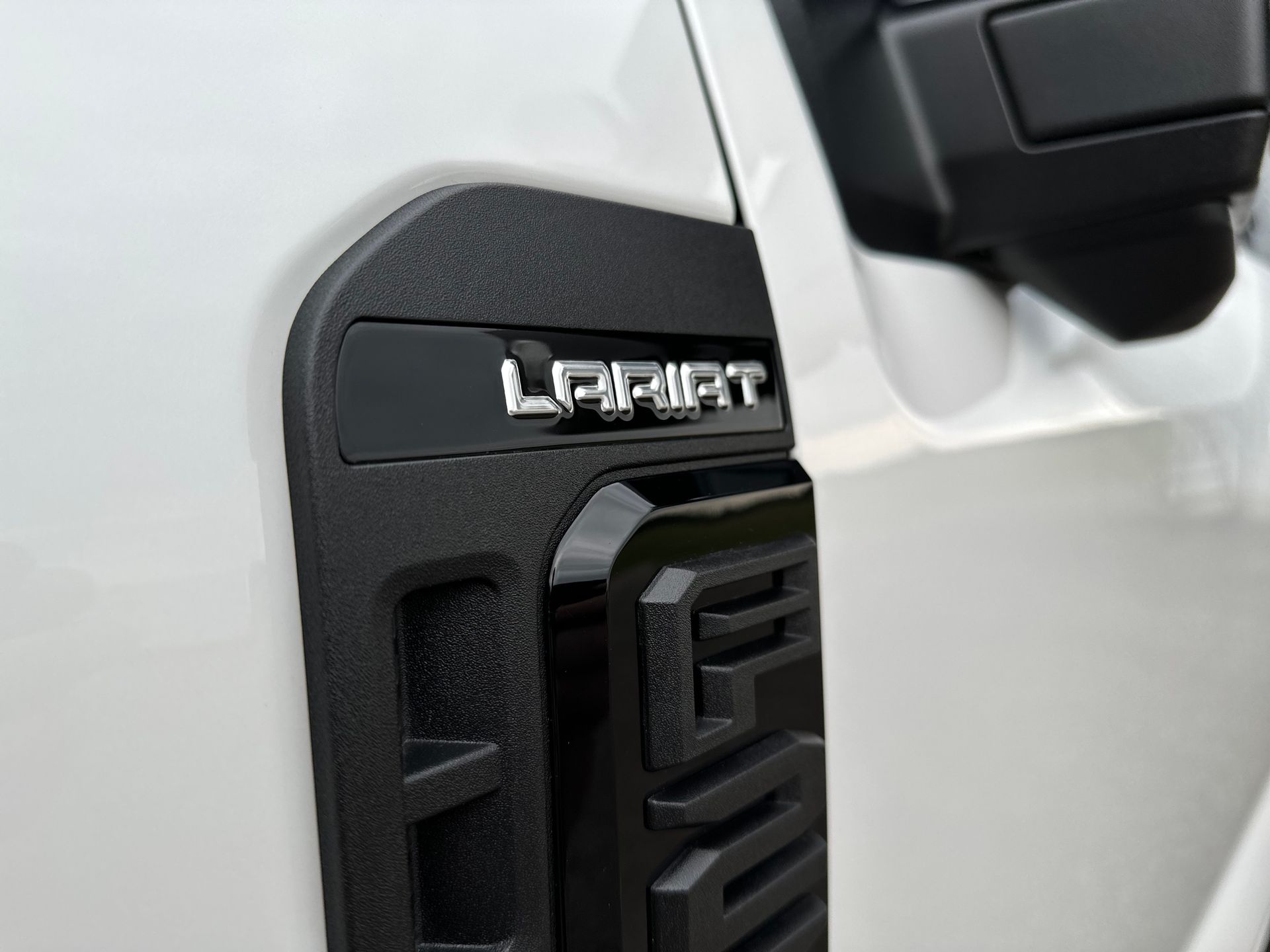 A white truck with a black fender emblem that says left