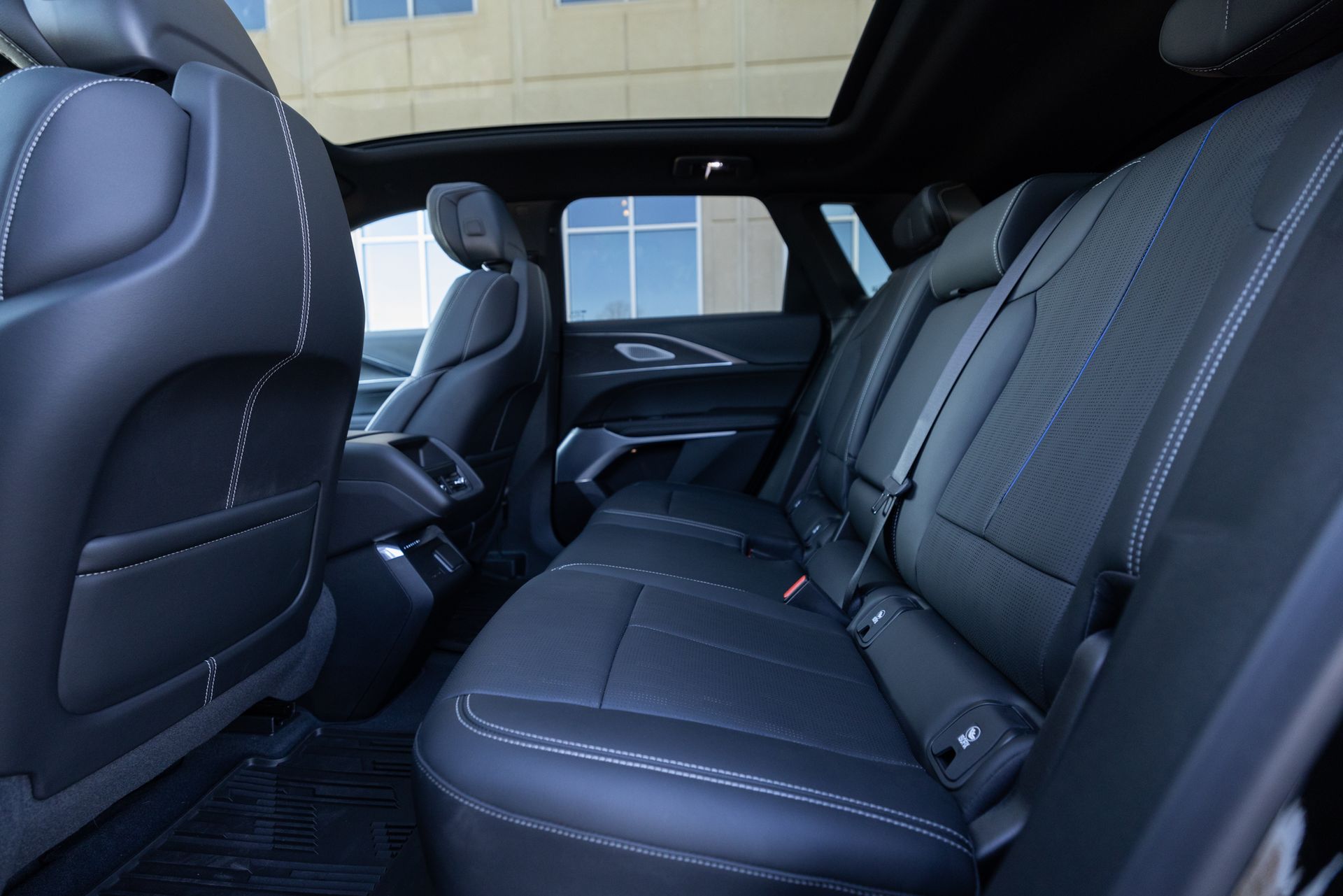 The back seat of a car with a sunroof.