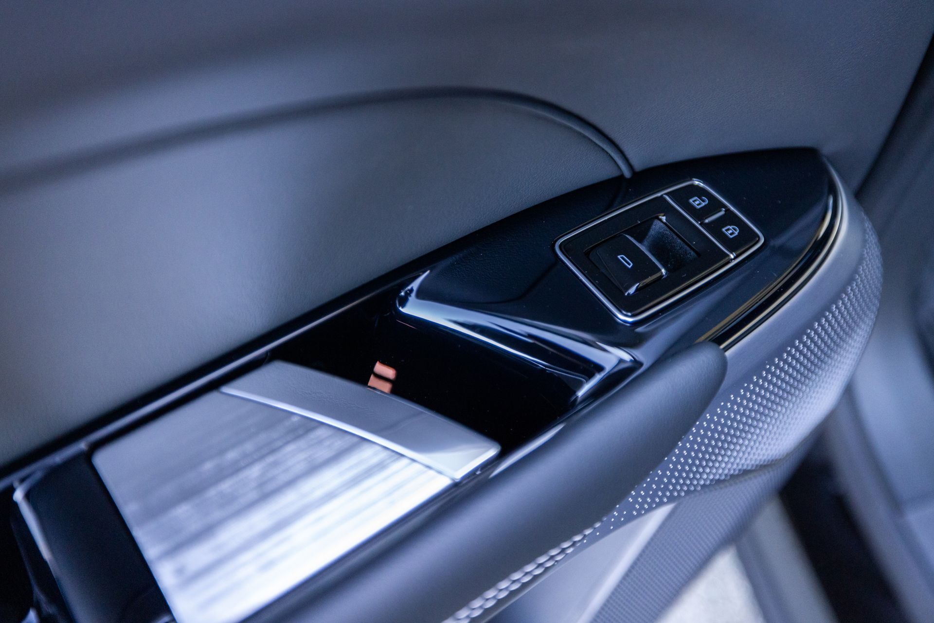 A close up of a car door handle with a button on it