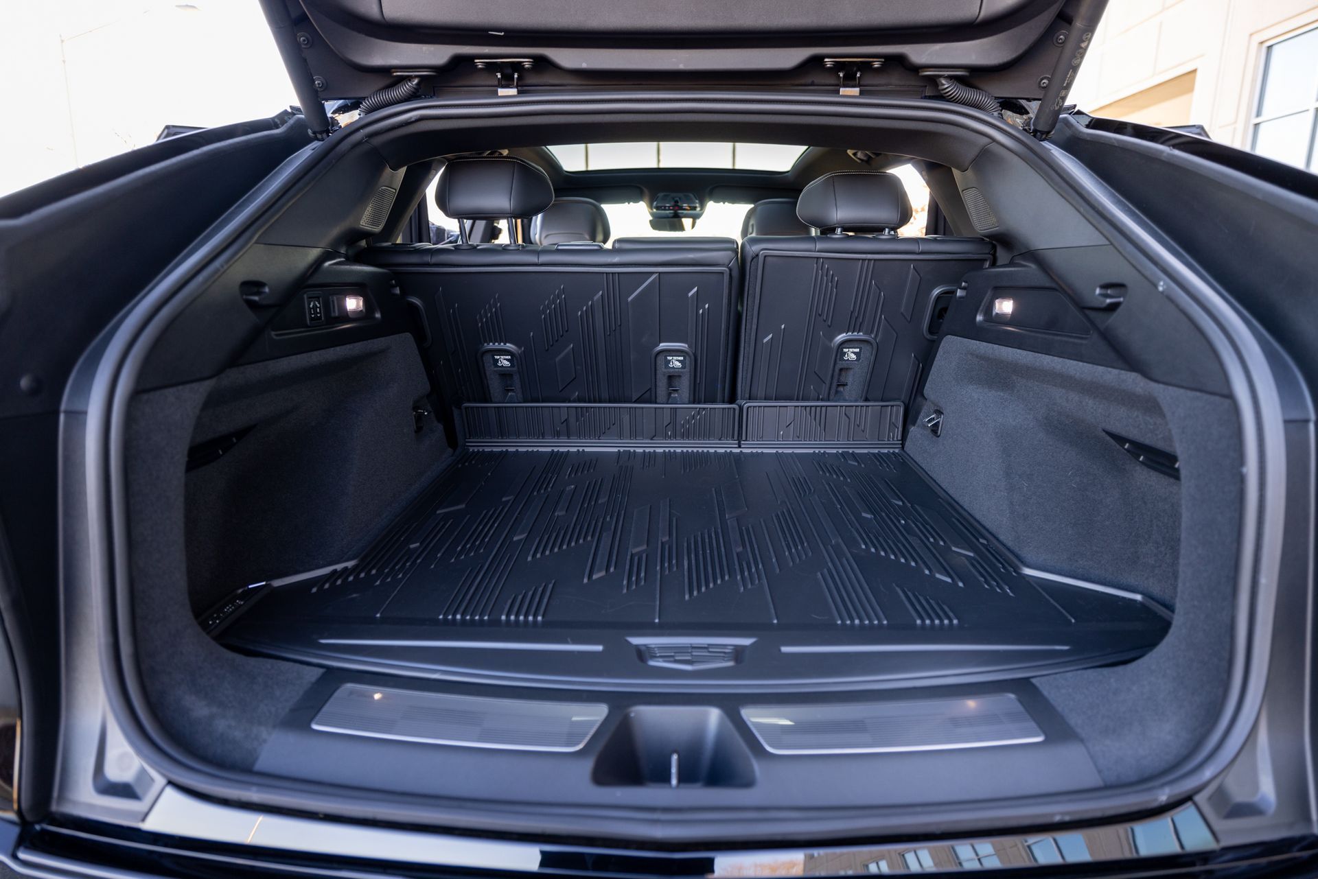 The trunk of a black car with the trunk lid open.