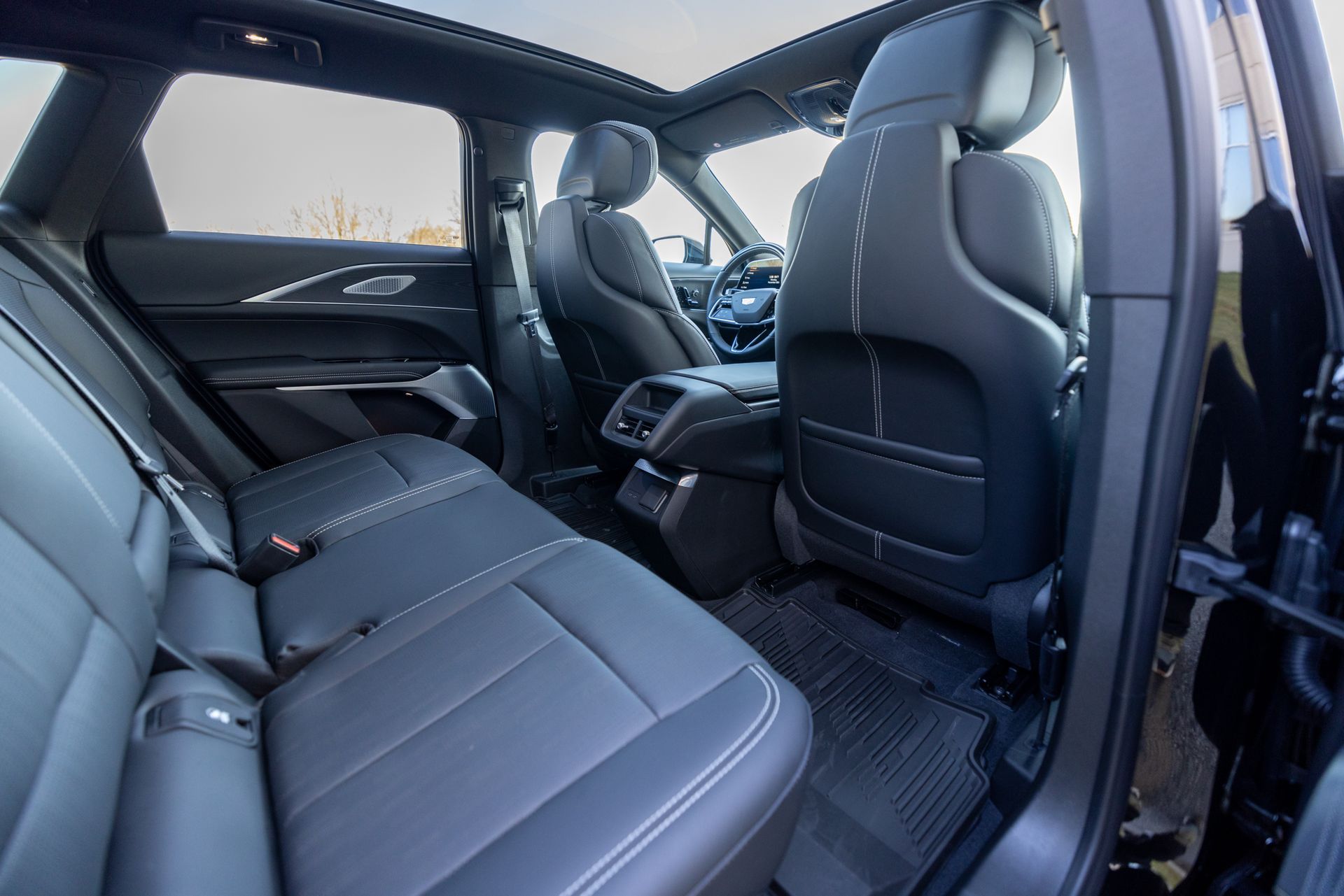 The back seat of a black car with a sunroof.