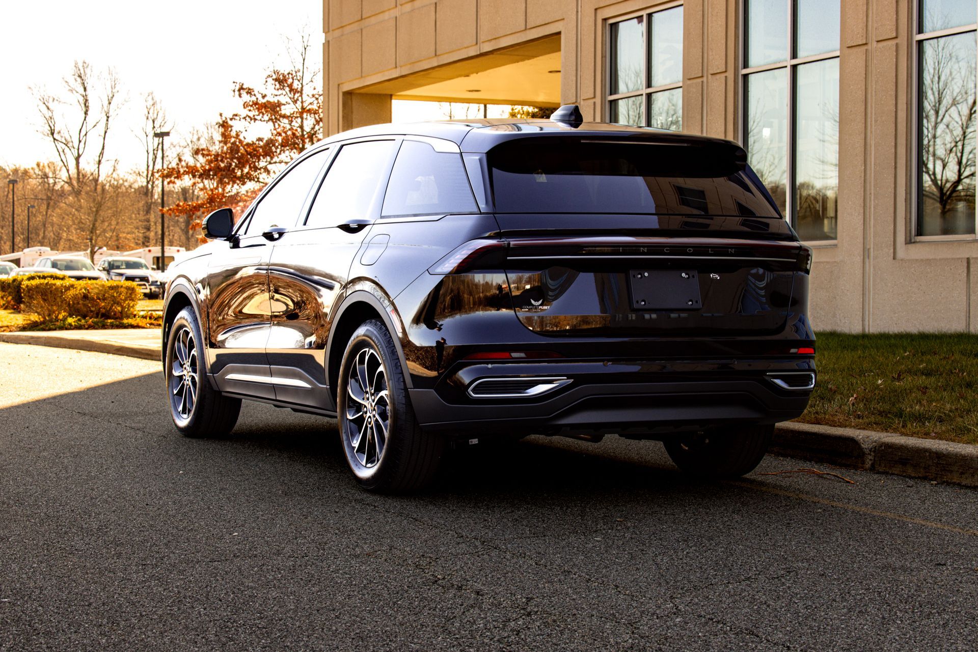 A black suv is parked in front of a building.
