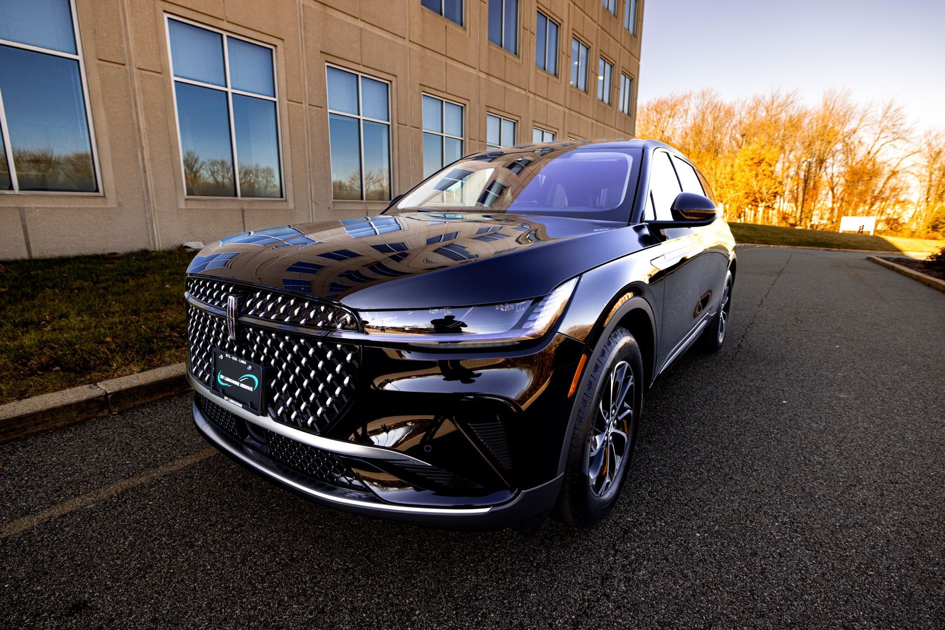 A black car is parked in front of a building.