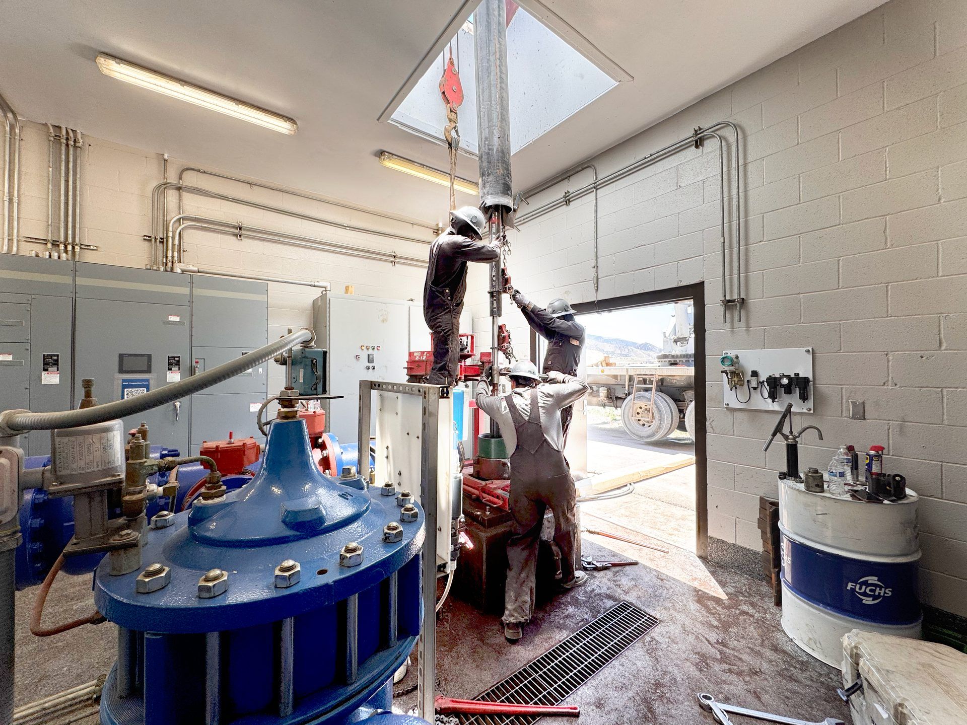 Technicians servicing a large pump in a municipal pump room