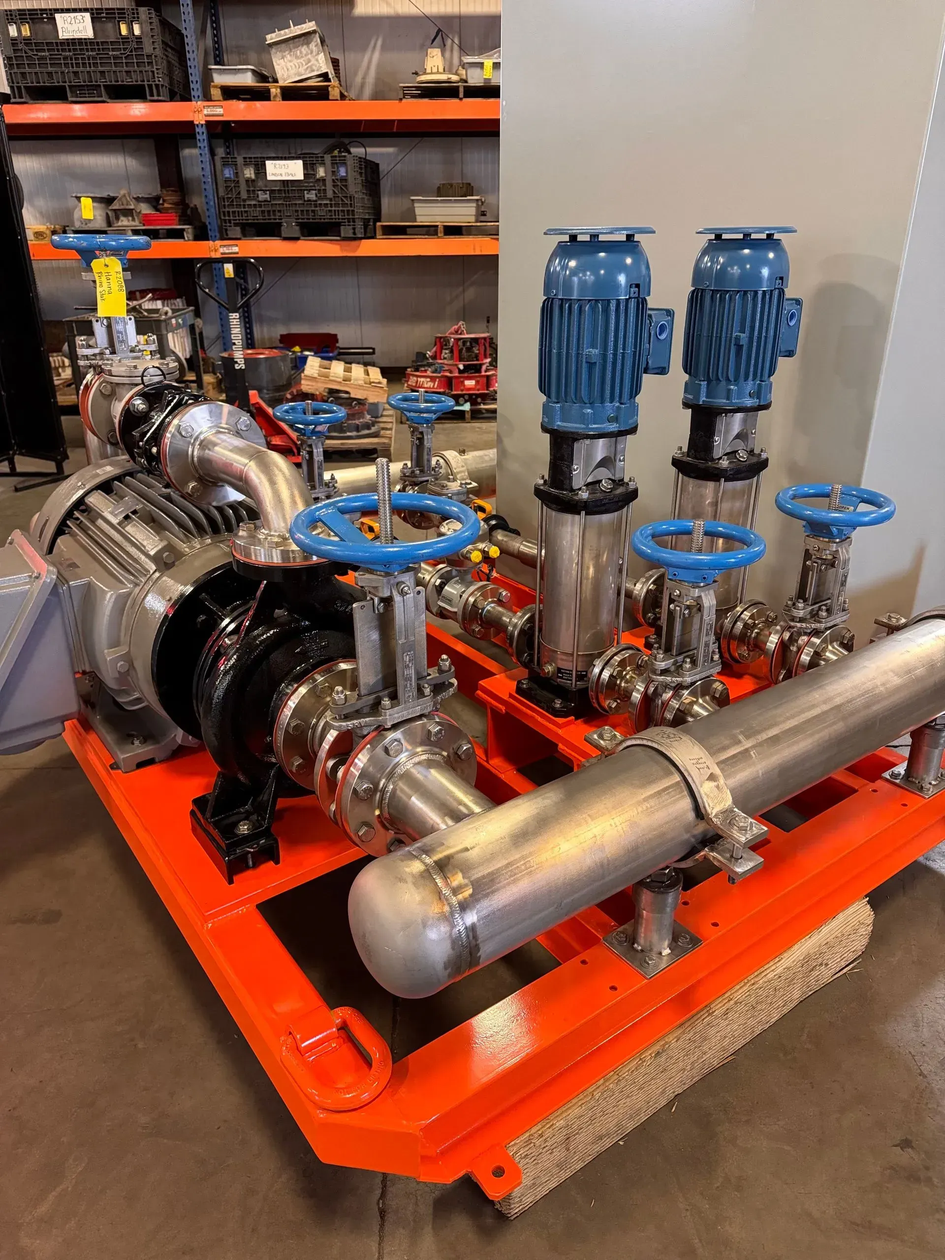 RhinoStak skid with vertical multistage pumps on an orange base frame in the shop