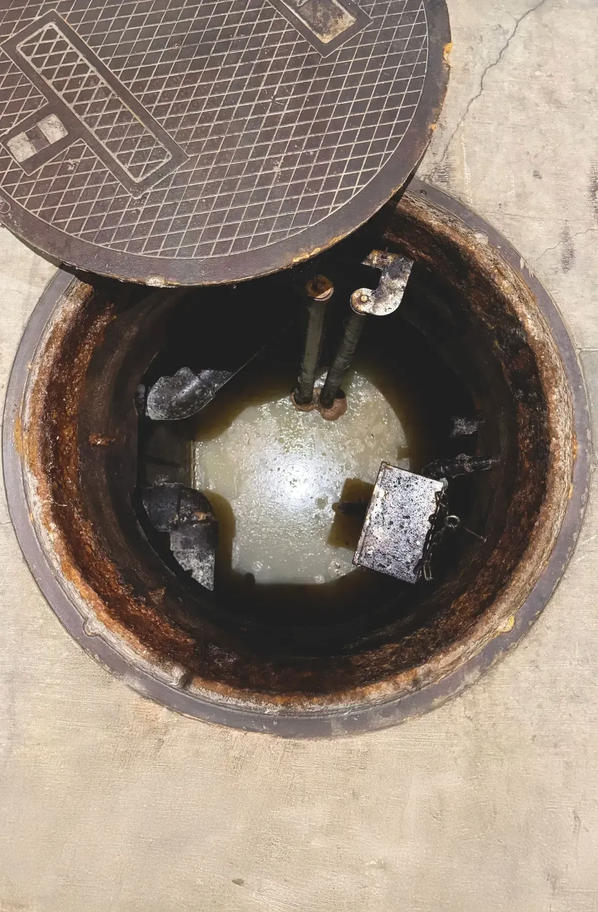 Before: conventional wet well below a manhole filled with wastewater