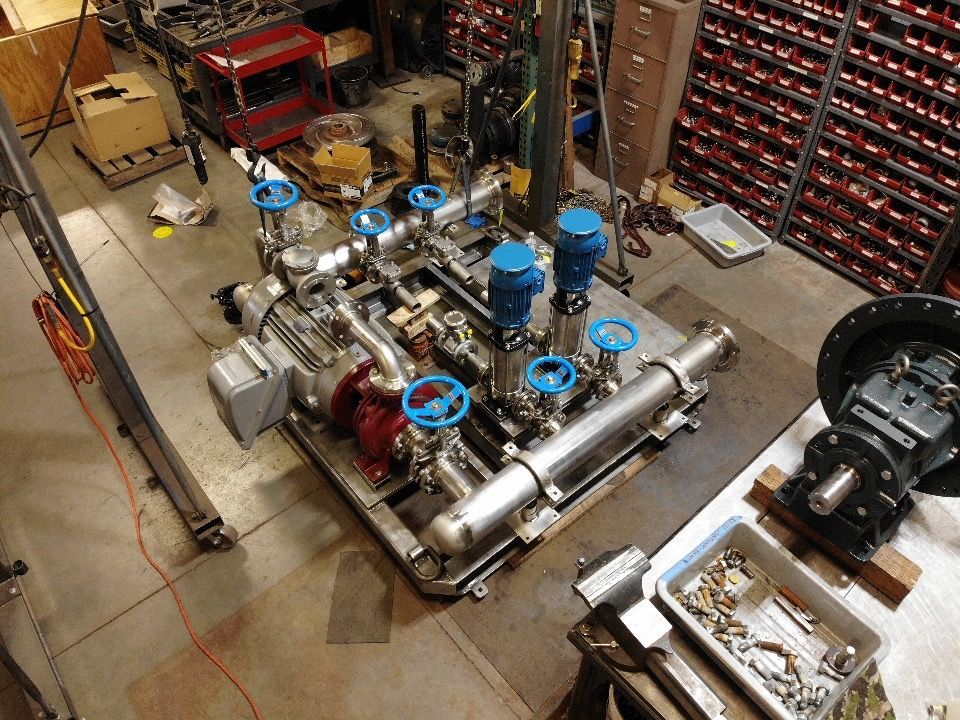 An aerial view of a machine with blue valves in a factory.