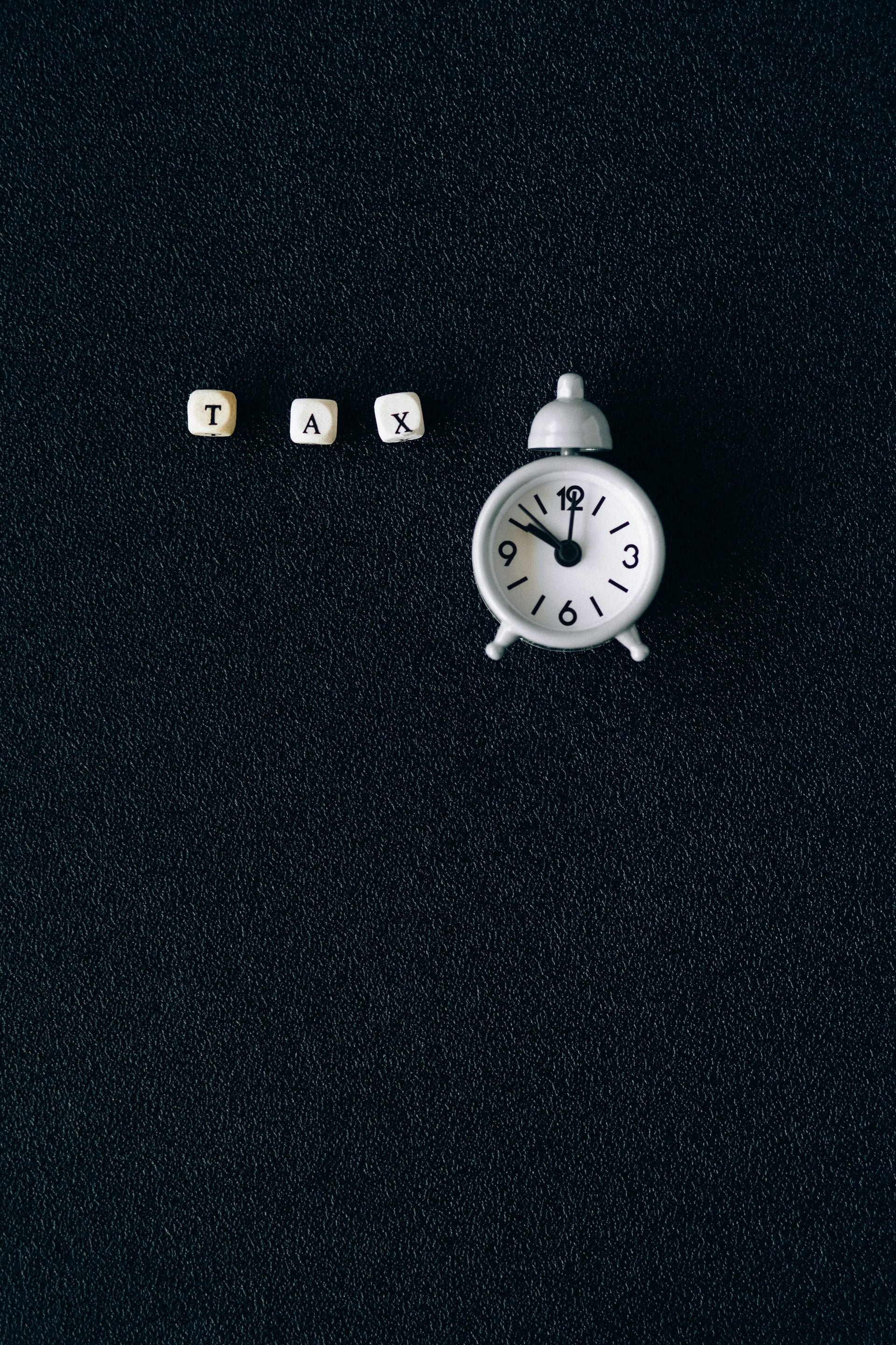 White alarm clock next to blocks spelling