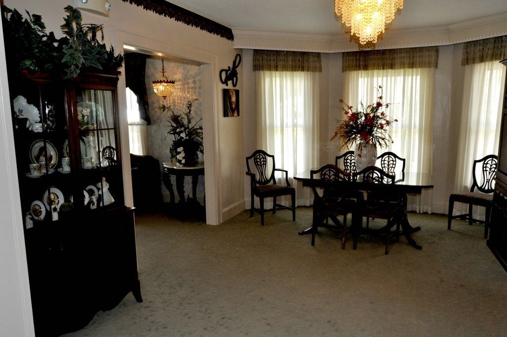 A dining room with a table and chairs and a chandelier