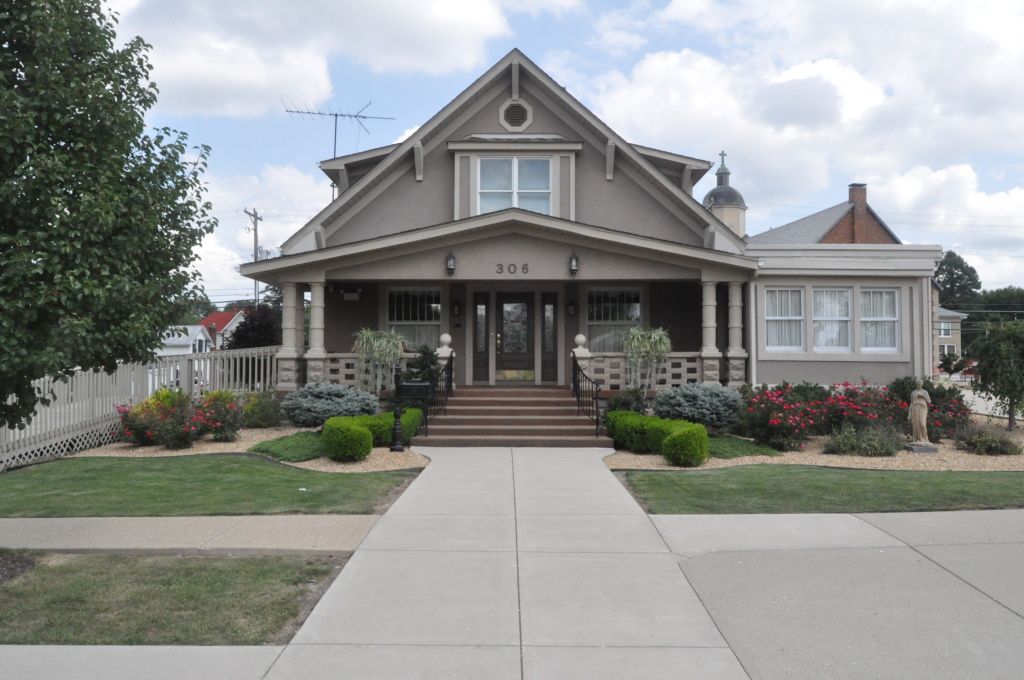 A large house with a concrete walkway leading to it