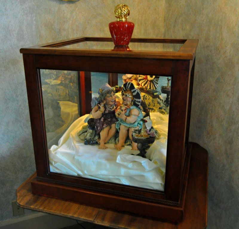 A display case with a statue of a woman and child inside of it
