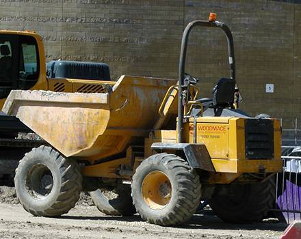 Un camion-benne jaune avec le mot woodmade dessus