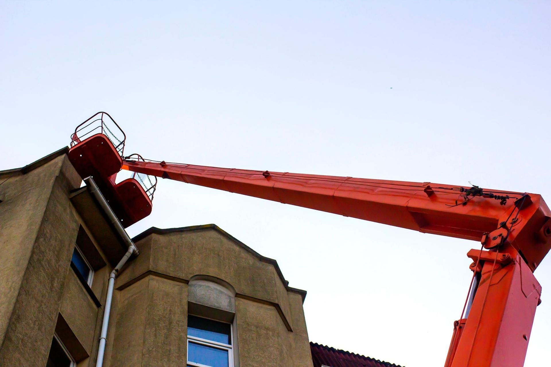 A large orange crane is working on a building.