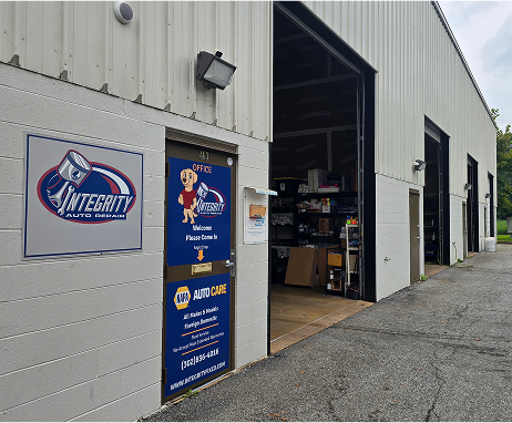 Auto repair shop exterior with open garage bays and sign: Integrity Auto Repair. | Integrity Auto Repair