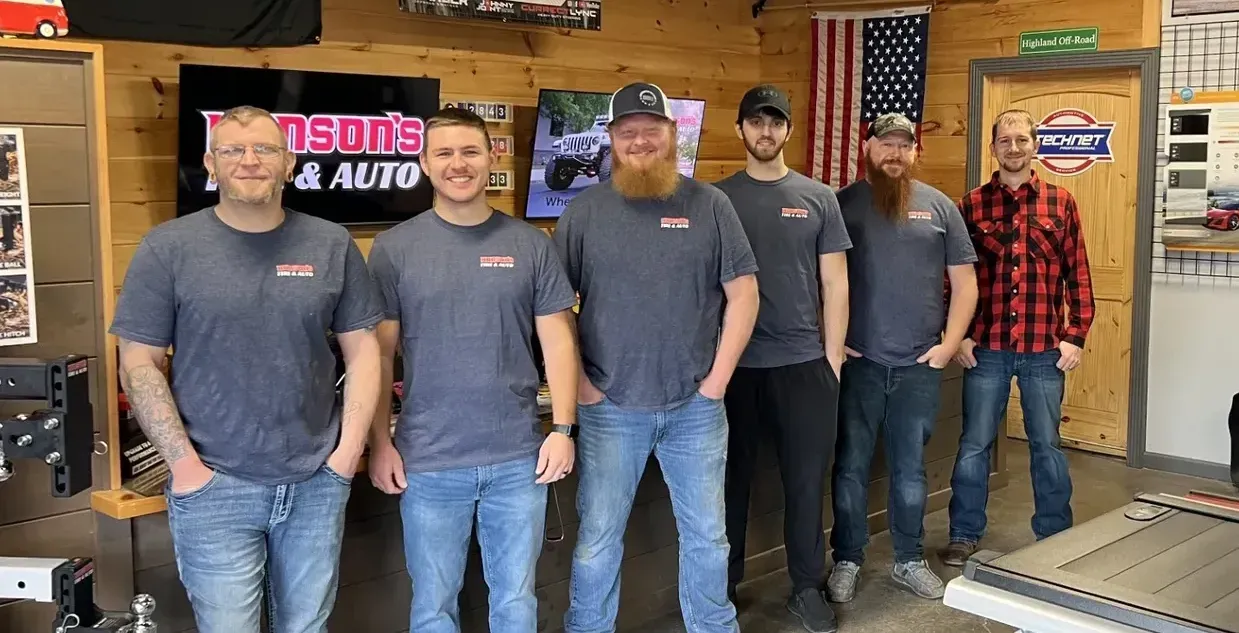 A group of men are posing for a picture in a garage.