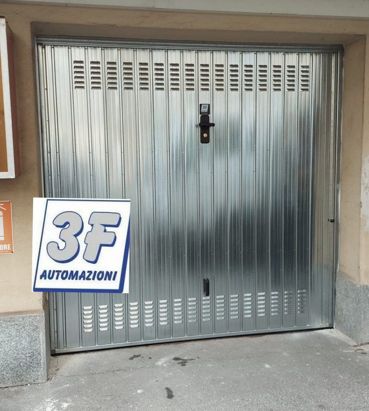 Porta da garage grigio con linee verticali e maniglia.