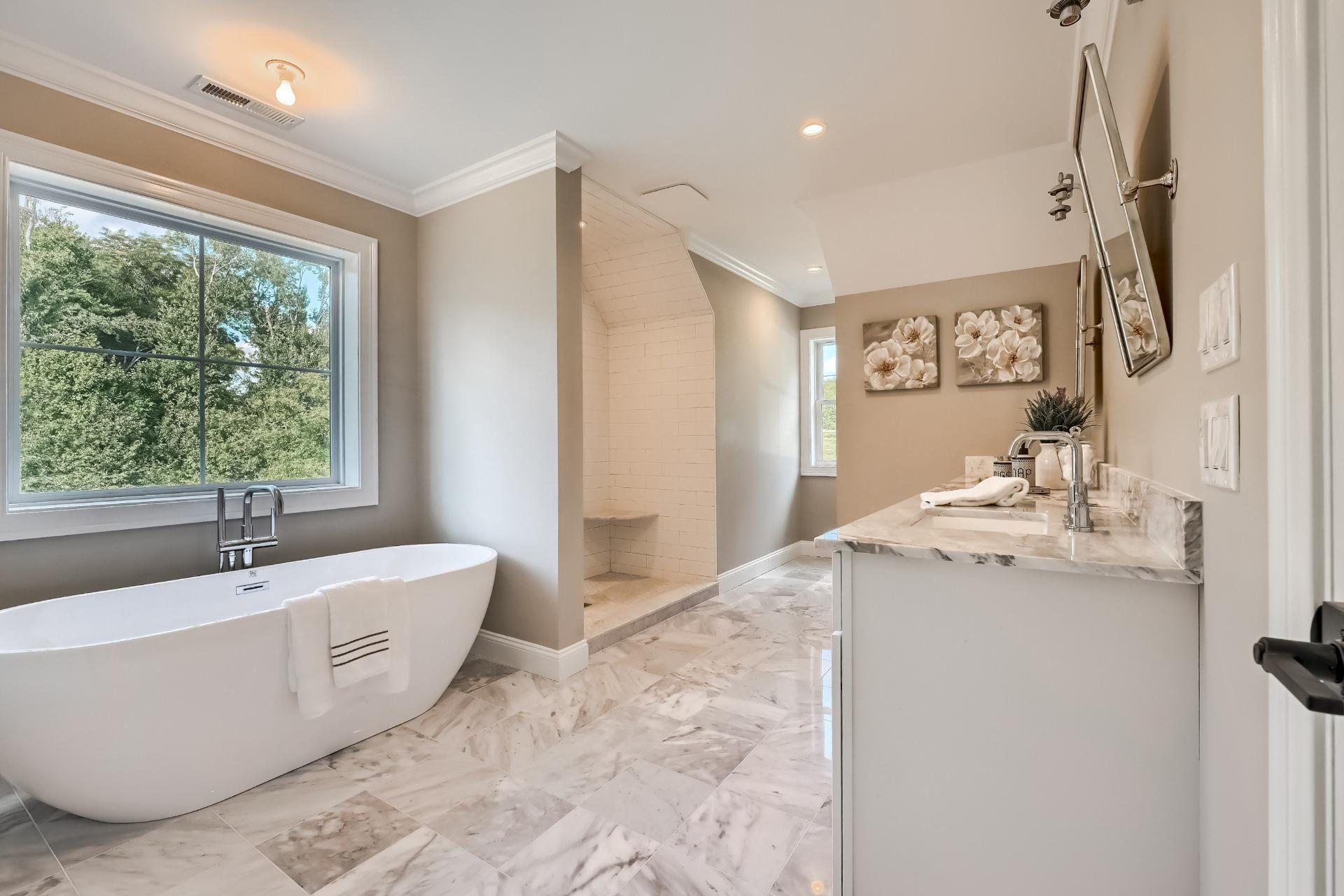 A bathroom with a tub , sink , and window.