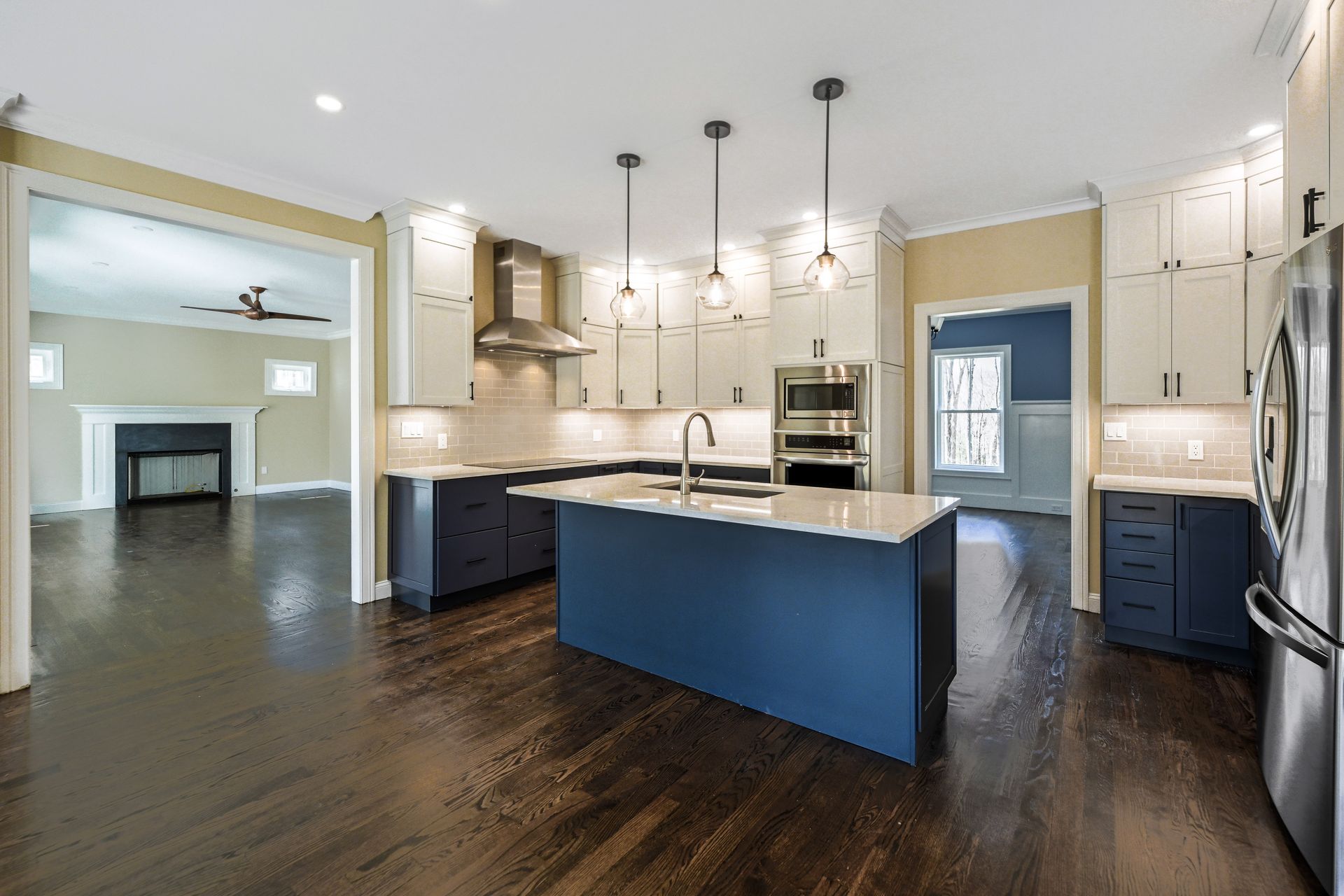 A kitchen with stainless steel appliances and a blue island.