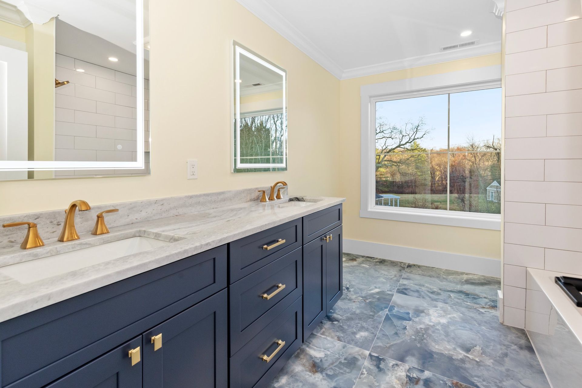 A bathroom with two sinks and a large window
