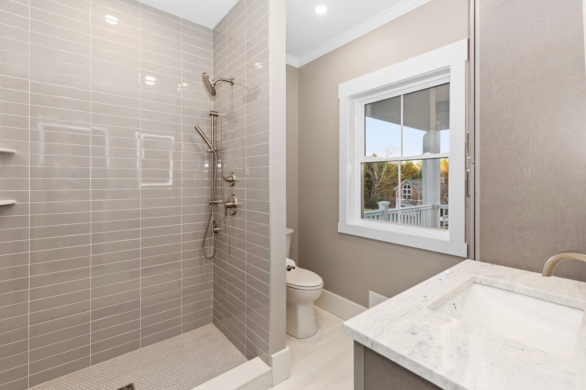 A bathroom with a walk in shower and a sink