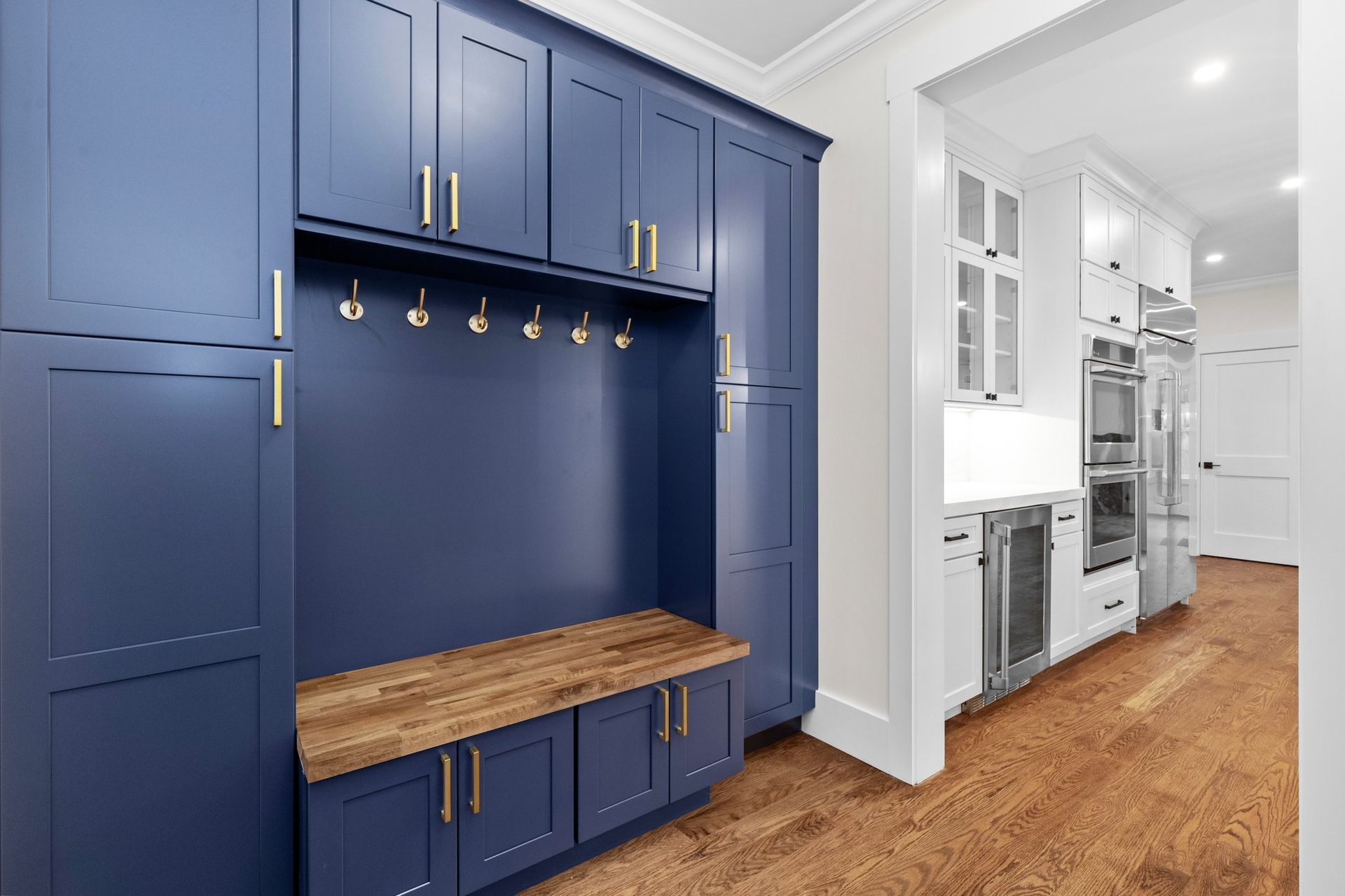 A hallway with blue cabinets and a wooden bench