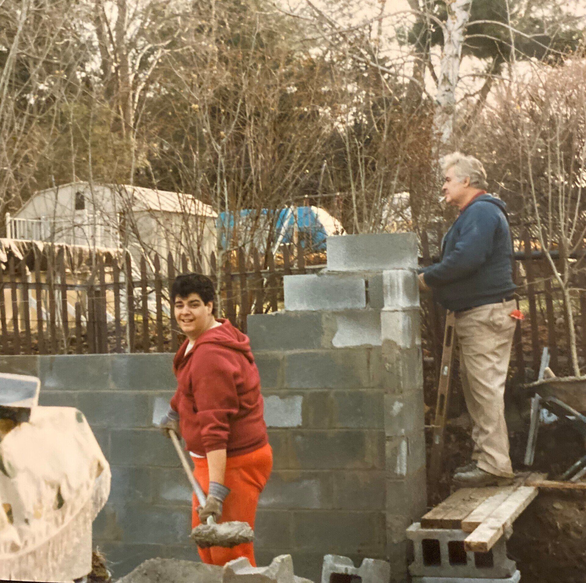 2 men working on a brick wall