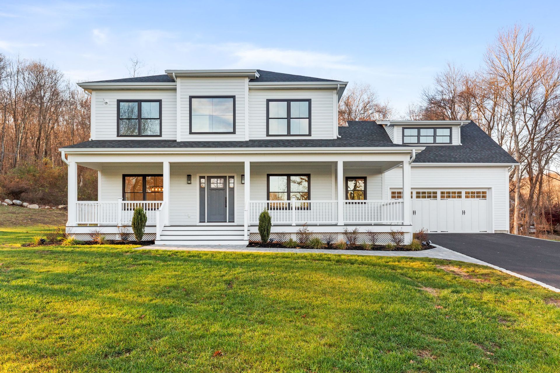 A large white house with a porch and a garage