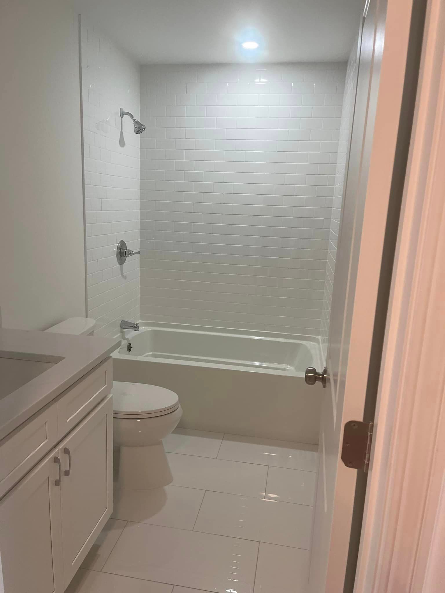 A bathroom with a toilet , tub , shower and sink.