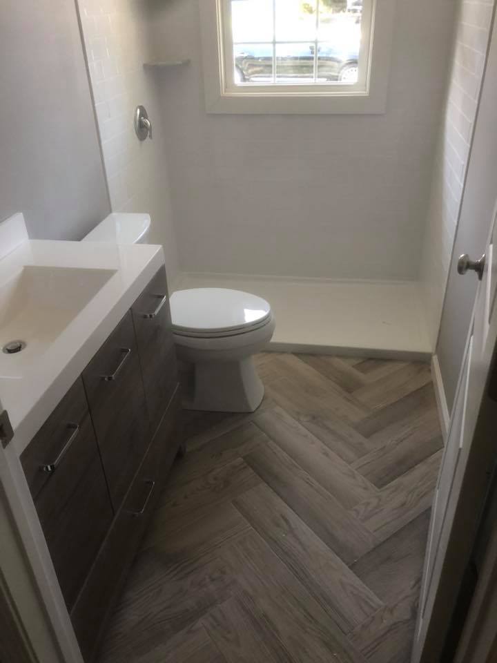 A bathroom with a toilet , sink , and shower.