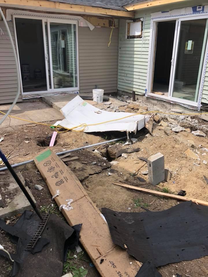 A house is being remodeled and there is a lot of dirt in the backyard.