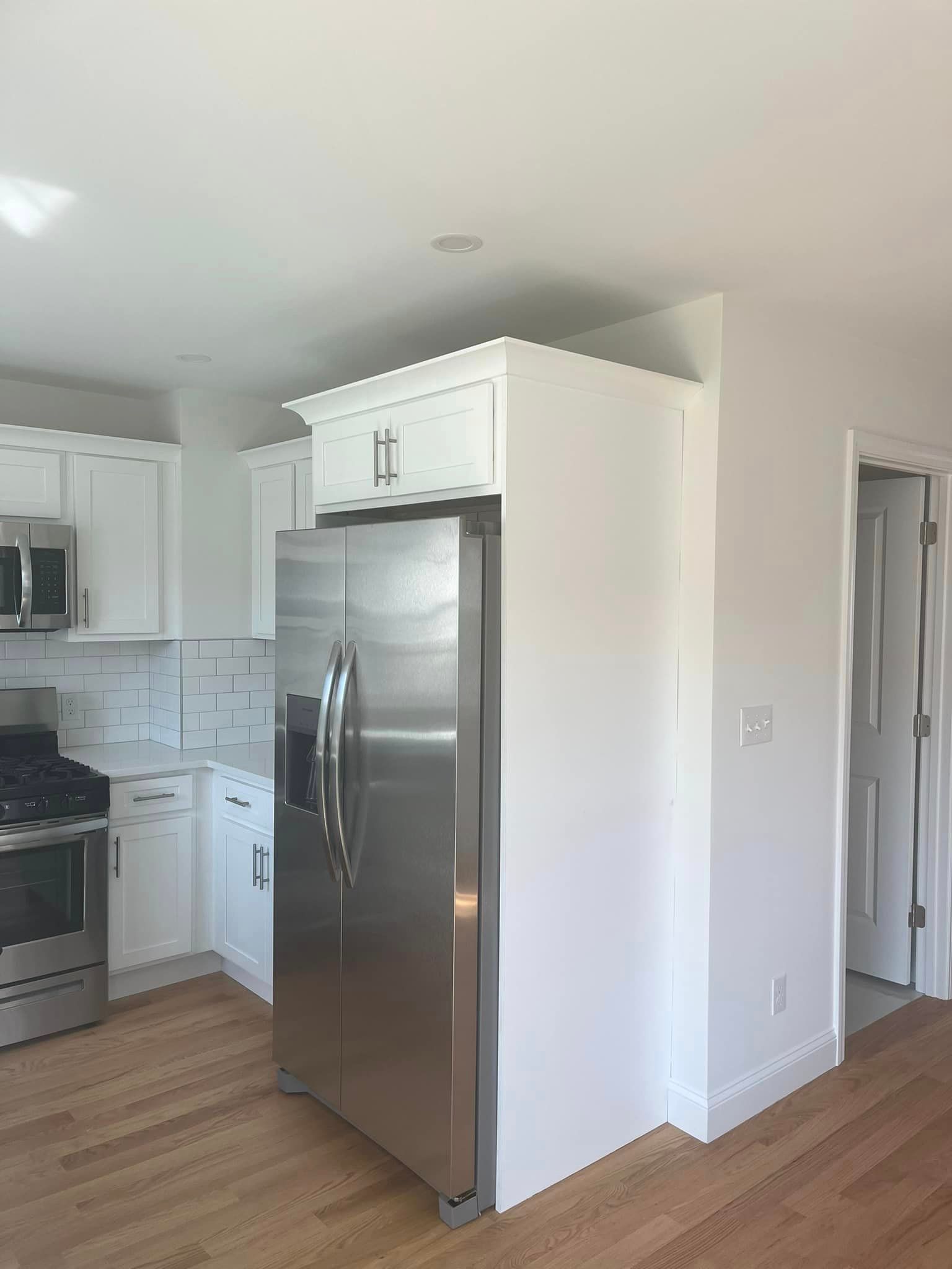 A kitchen with stainless steel appliances and white cabinets