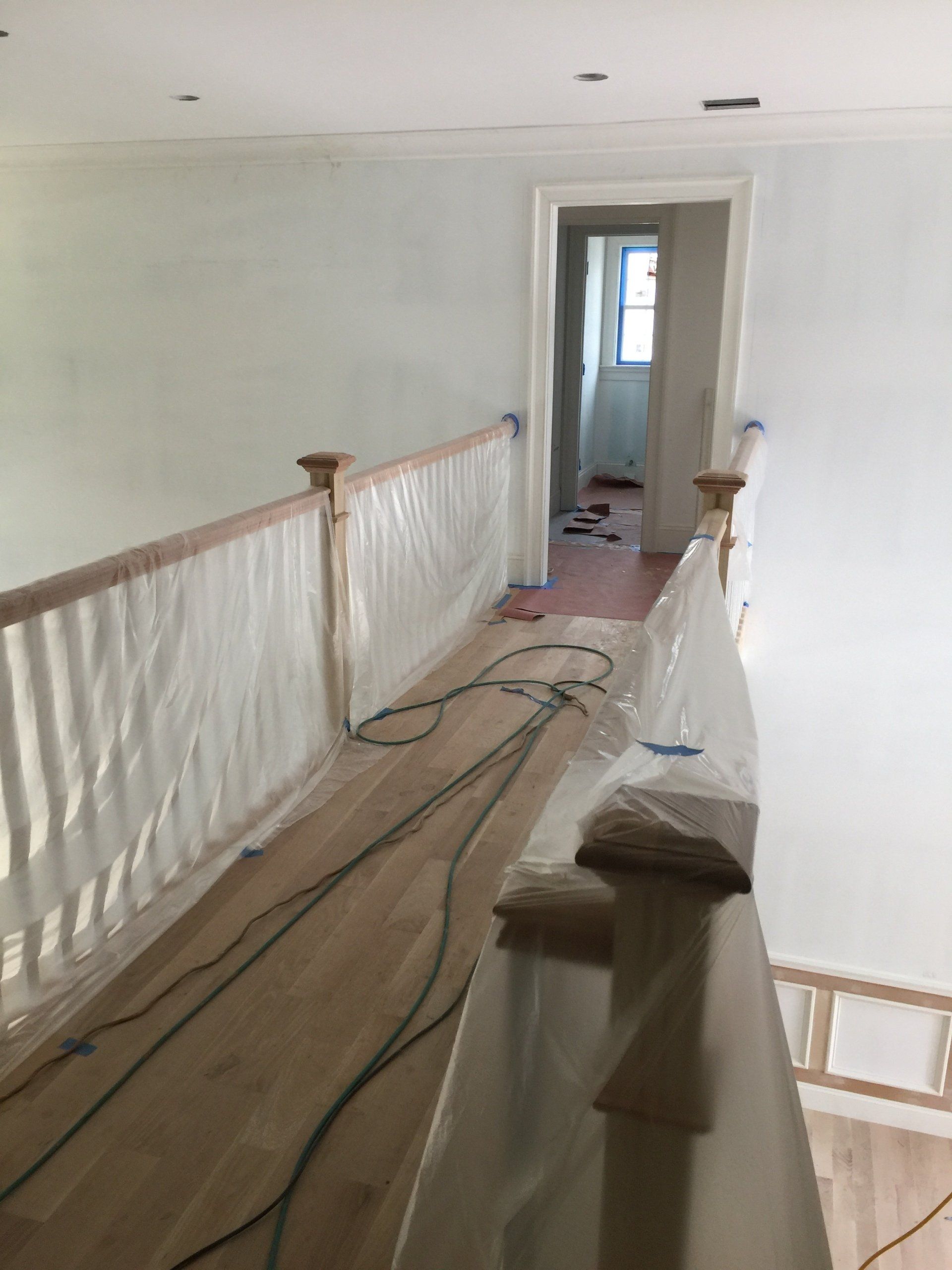 A hallway with a wooden railing covered in plastic
