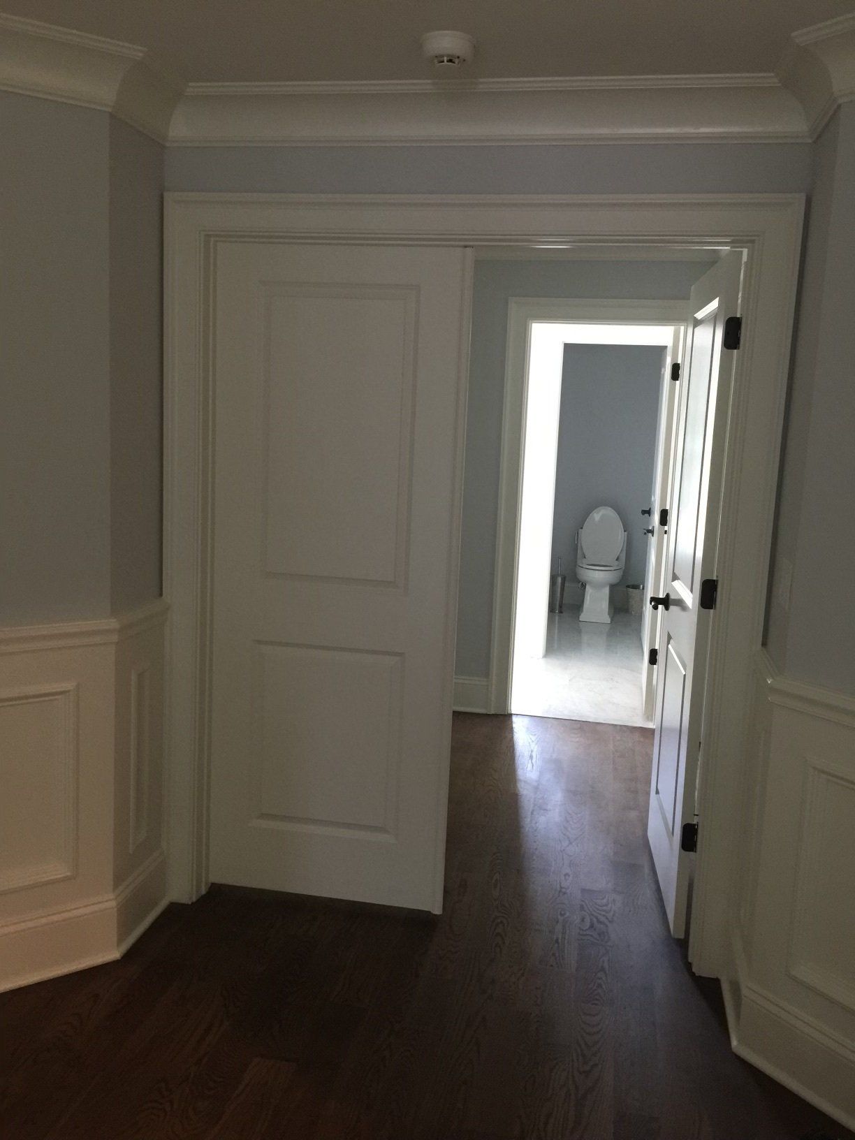 A hallway leading to a bathroom with a toilet