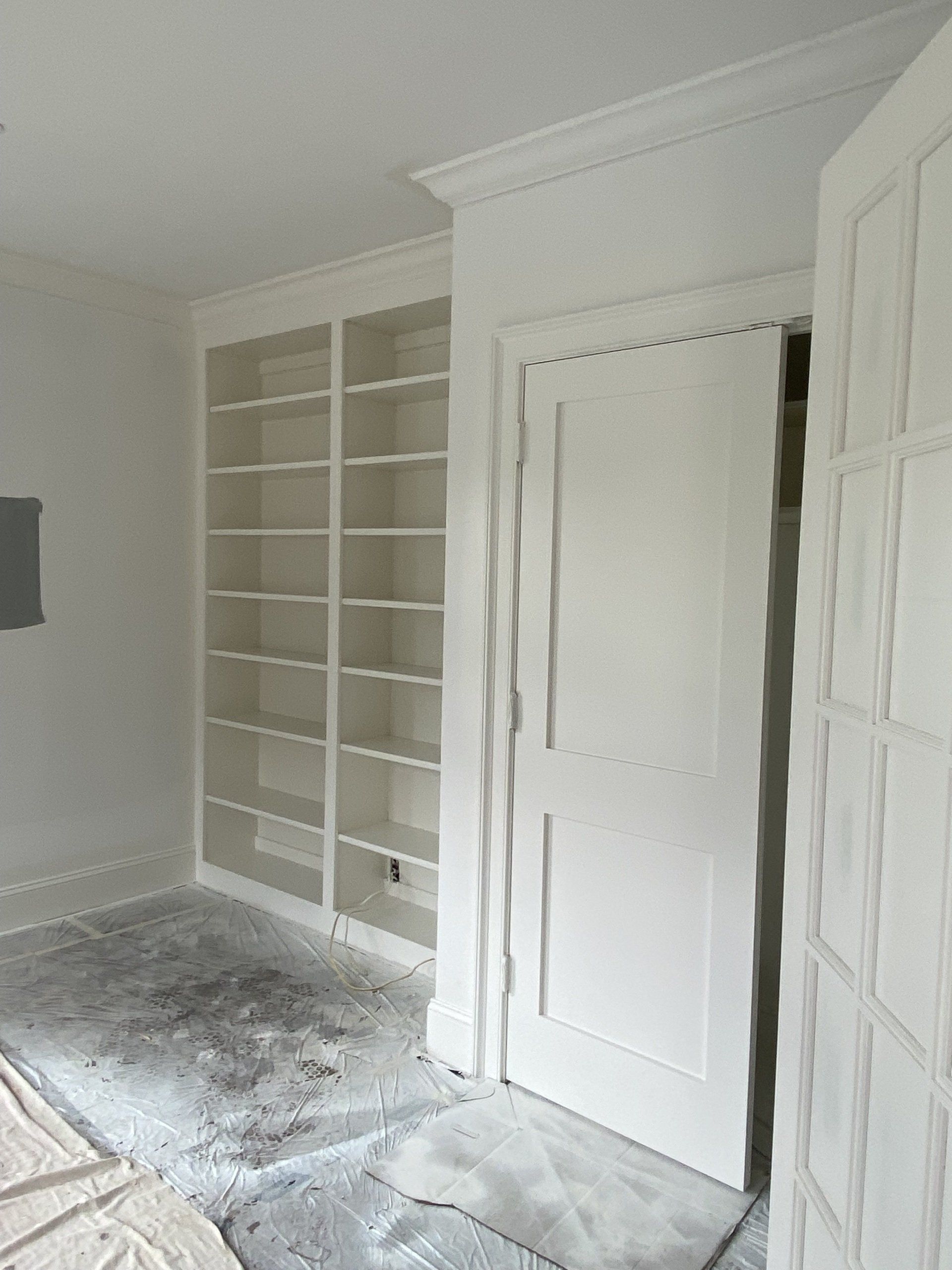 A room with a door and shelves in it