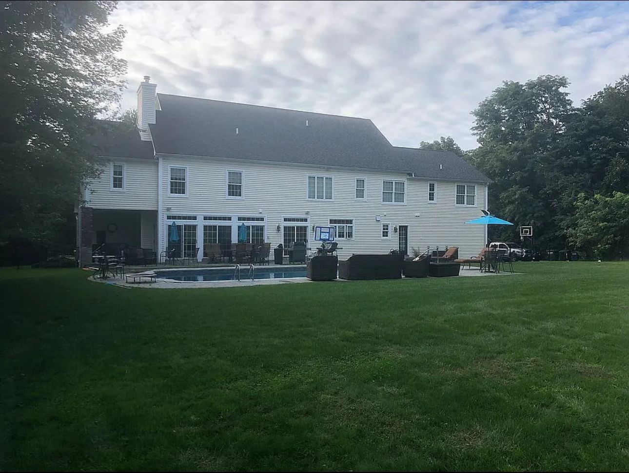 A large white house with a swimming pool in the backyard