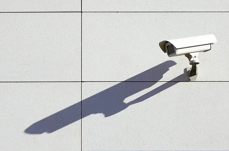 A security camera is sitting on the side of a building