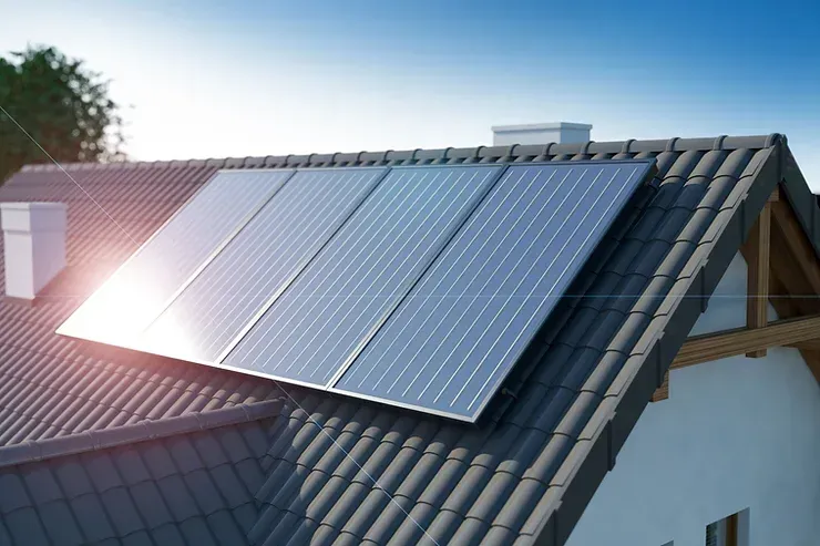 The sun is shining through the solar panels on the roof of a house.
