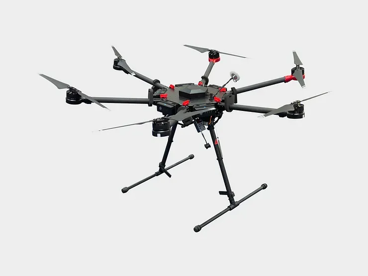 A black and red drone is sitting on a stand on a white background.