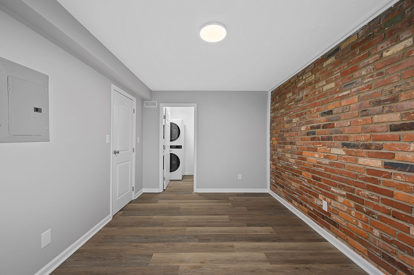 an image of an interior room with exposed brick looking at the washer and dryer