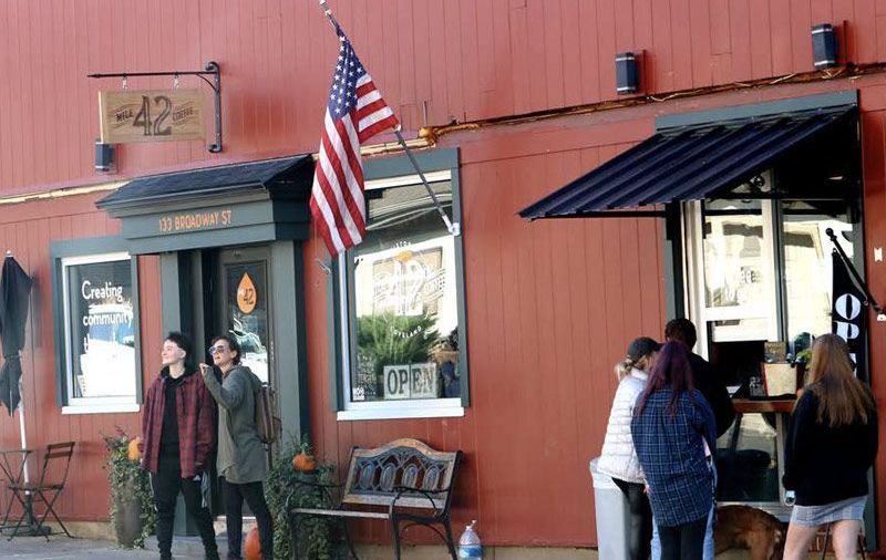 picture of a coffee shop and people standing in front of the building
